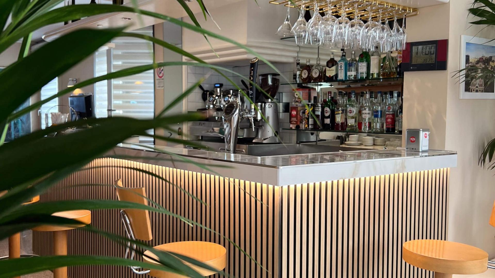 Stylish modern bar with high stools and displayed bottles.