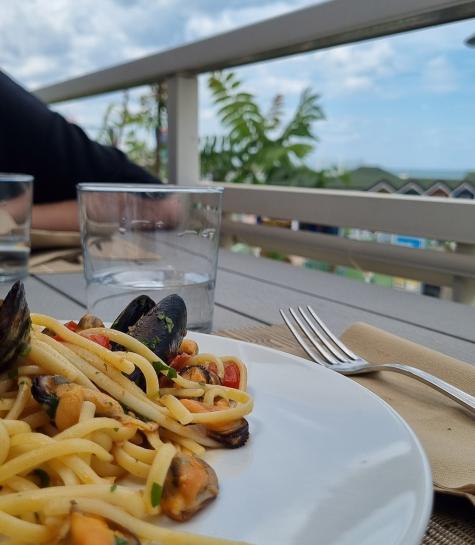 Seafood pasta dish on a scenic terrace.